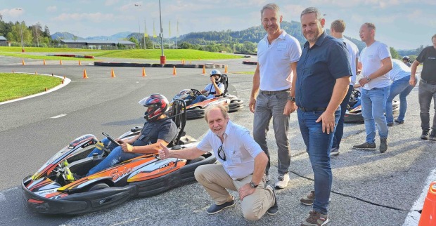 Personen stehend und kniend mit Go-Kart am Fahrsicherheitszentrum