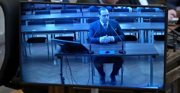 Aufnahme eines Monitors, auf dem Florian Teichtmeister während seiner Gerichstverhandlung zu sehen ist.