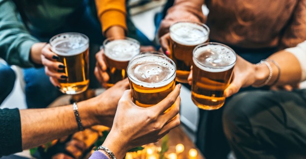 Mehrere Männder stoßen mit Bier an.
