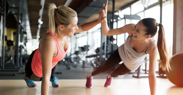 Trainerin in Fitnessstudio mit Frau