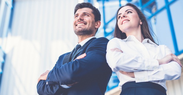 Junge erfolgreiche Frau und junger erfolgreicher Mann in blauer Businesskleidung | Credit: iStock.com/Viacheslav Peretiatko