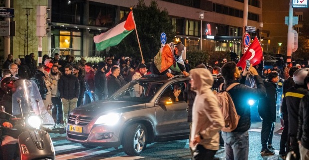 Menschen demonstrieren nach dem Angriff auf ein Krankenhaus im Gazastreifen. Sie schwenken Fahnen.