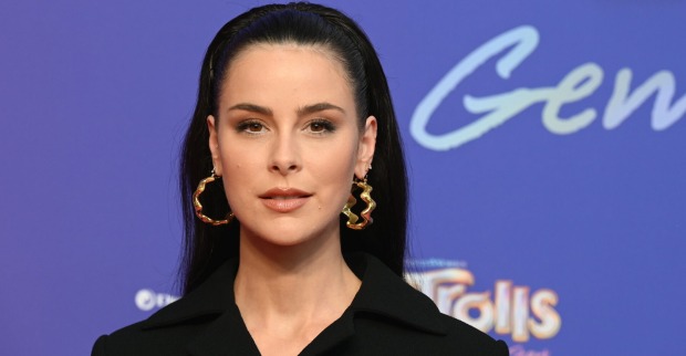 Lena Meyer Landrut mit offenen Haaren, einem Haarreifen, großen Ohrringen und einem schwarzen Sakko.
