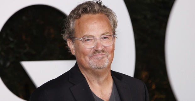 Matthew Perry beim CQ Award mit einem schwarzen Anzug und einer Brille.