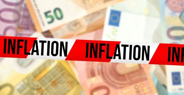 Mehrere Geldscheine übereinander, darüber ein Sperrband mit der Aufschritt "Inflation"