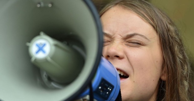 Greta Thunberg schreit mit geschlossenen Augen in ein Megaphon