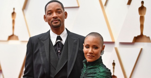 Will Smith trägt ein Sakko und Jada Smith ein hochgeschlossenes dunkelgrünes Kleid.