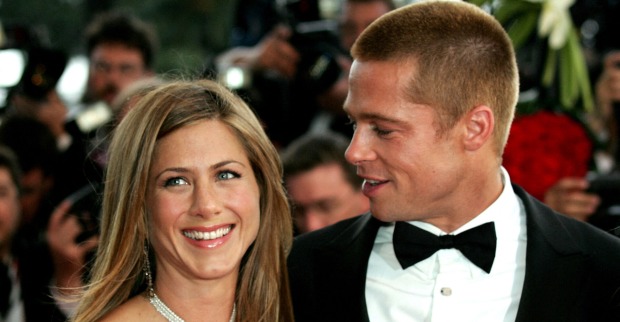 Brad Pitt und Jennifer Aniston. Sie hat offene blonde Haare und er trägt einen Smoking mit einer schwarzen Fliege.