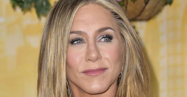 Jennifer Aniston trägt offene blonde Haare und hat ein schimmerndes Augen Make-Up. Sie schaut in die Ferne.
