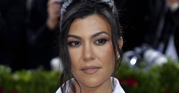 Kourtney Kardashian trägt hochgeschlossene schwarze Haare. Sie steht auf dem roten Teppich.
