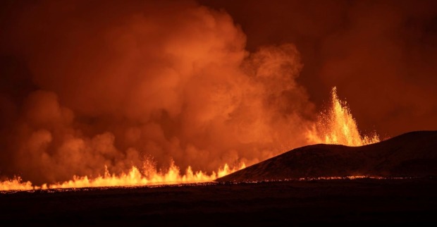 Ein Riss in der Erde aus dem Lava in einer Fontäne in den dunklen Himmel schießt