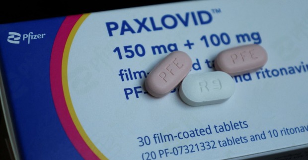 Eine Packung Paxlovid und drei einzelne Tabletten.