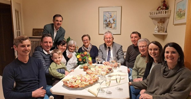 Menschen sitzen um den Tisch, um Geburtstag zu feiern