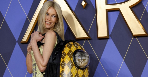Claudia Schiffer auf dem roten Teppich mit einer Katze im Rucksack.