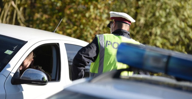 Ein Polizist kontrolliert einen Autofahrer.