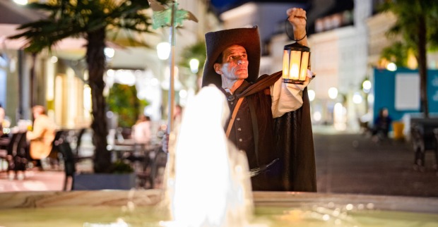 Horst Ragusch mit Laterne in der Hand vor Springbrunnen