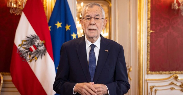 Alexander Van der Bellen hält eine Ansprache in der Präsidentschaftskanzlei der Hofburg, hinter ihm die österreichische und europäische Flagge.