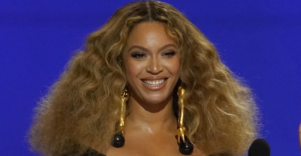 Beyoncé mit offenen, voluminösen Haaren auf einer Tribüne.