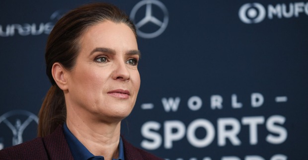 Katharina Witt vor einer Fotoleinwand mit geschlossenen Haaren.