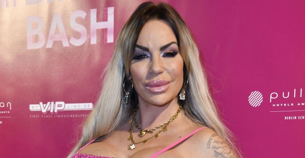 Gina Lisa Lohnfink vor einer pinken Fotowand.