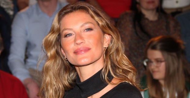 Gisele Bündchen mit offenen blonden Haaren und einem schwarzen Top.