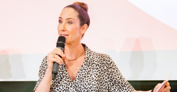 Kathi Bellowitsch mit einem Mikrofon auf einem Podium.