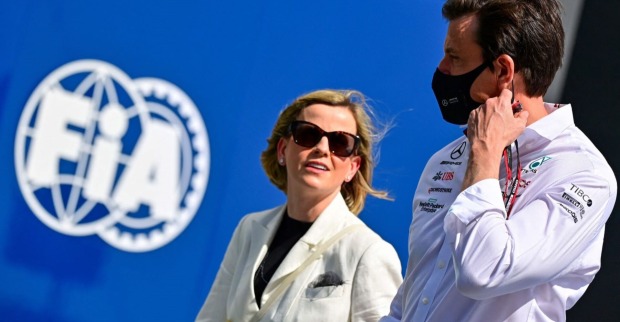 Susie und Toto Wolff vor dem Logo der FIA. Toto Wolff trägt eine Maske
