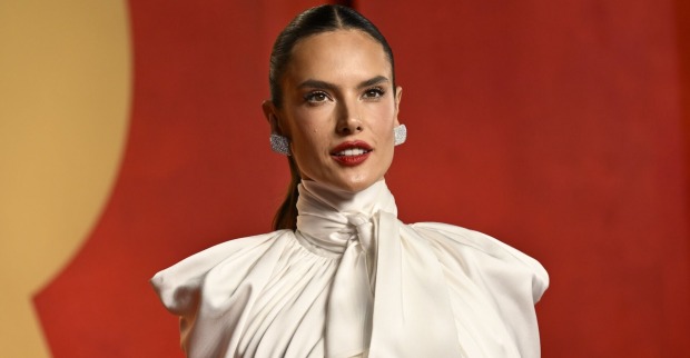 Alessandra Ambrosio mit einem weißen Oberteil und zurück gegelten Haaren auf dem Red Carpet.
