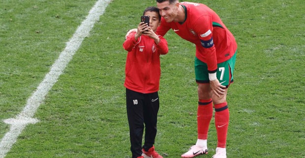 Ein Fußballspieler macht gemeinsam mit einem Fan ein Selfie