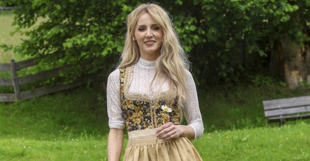 Melissa Naschenweng mit blonden offenen Haaren und einem Dirndl.