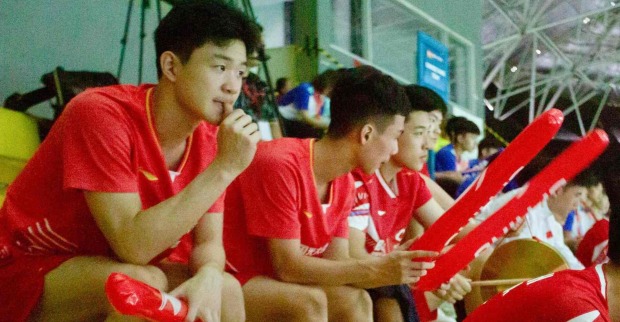 Chinesische Badmintonspielerinnen und -spieler beobachten und unterstützen ihre Mannschaftskameradinnen und -kameraden von der Tribüne aus bei den Junioren-Asienmeisterschaften 2024 in Yogyakarta.