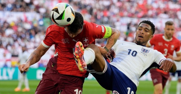 Englands Jude Bellingham (rechts) und der Schweizer Granit Xhaka kämpfen während eines Viertelfinalspiels zwischen England und der Schweiz bei der Fußball-Europameisterschaft 2024 in Düsseldorf um den Ball,