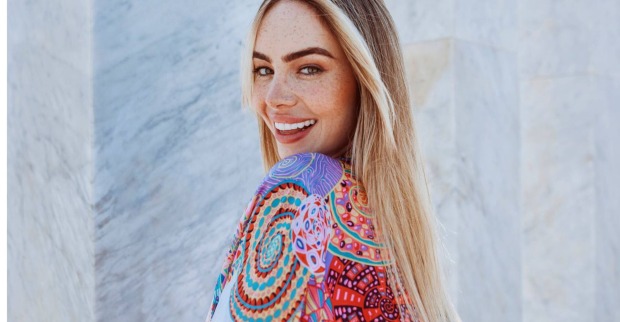 Blonde Frau im sommerlichem bunten Kleid lächelt