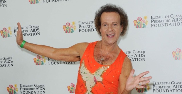 Richard Simmons, immer grinsend, wirft sich im Fitness-Outfit am Roten Teppich in Pose