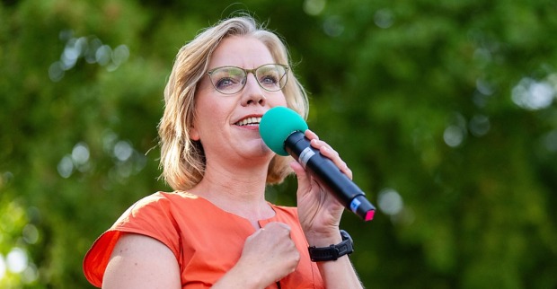 Leonore Gewessler mit Mikrofon auf einer Bühne.