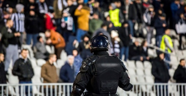 Polizist in voller Montur auf Fußballplatz