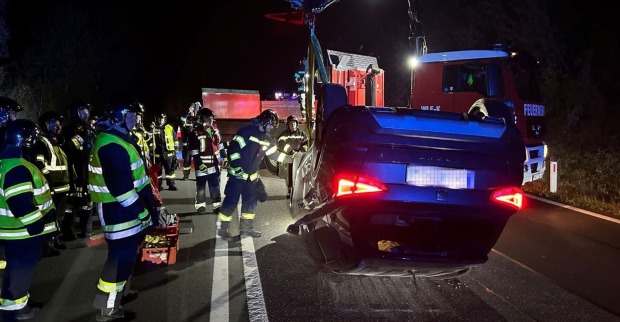 Einsatzkräfte der Feuerwehr vor Ort beim Unfallwagen.