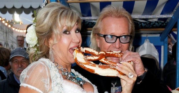 Carmen und Robert Geiss beißen in eine Brezel.