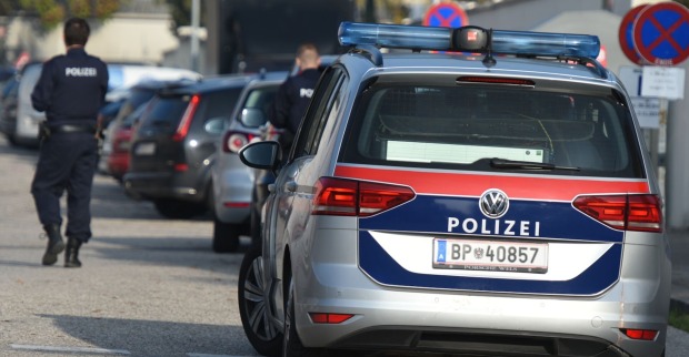 Polizeibeamter neben Polizeiwagen