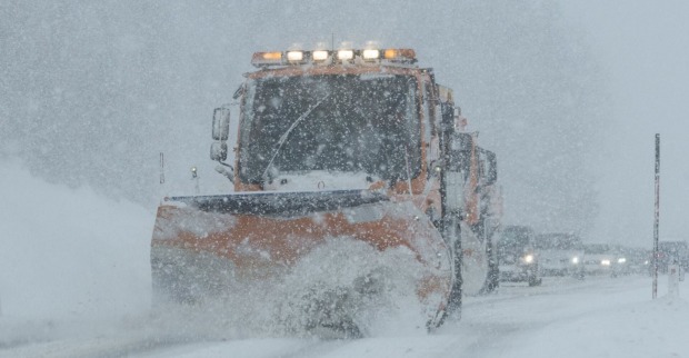 Ein Schneepflug auf einer Landstraße.