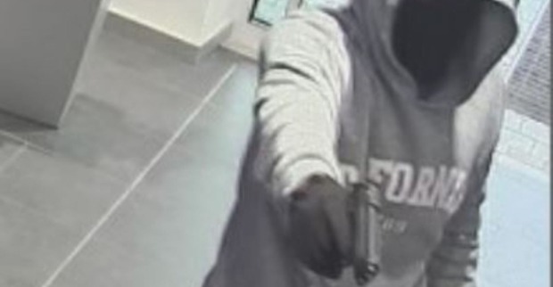 Der Täter ist mit einer Pistole bewaffnet.