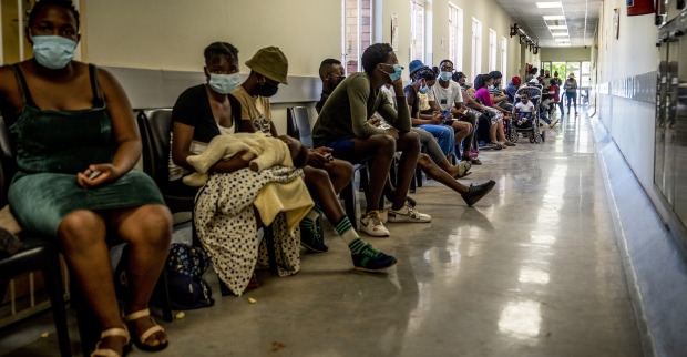 Menschen warten in Afrika im Spital auf einen Arzt.