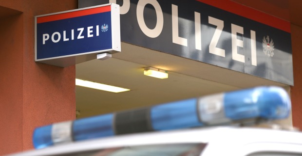 Blaulichtanlage eines Polizeiautos vor einem Gebäude mit einem Schild auf dem das Wort „Polizei“ steht.