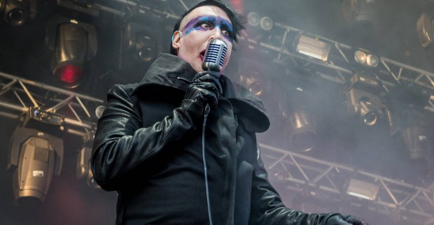 Marilyn Manson während eines Live-Auftritts, bei dem er einen langen schwarzen Mantel und blau-weißes Make-up trägt