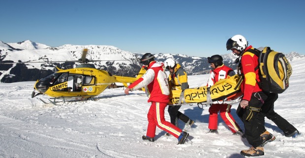 Rettungshubschrauber und Helfer an einem Einsatzort auf der Piste.