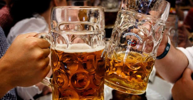 Zwei Menschen prosten mit einem Bierkrug.