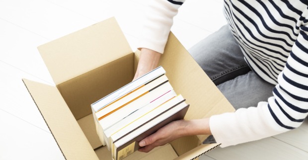 Perspektive von oben, Frau packt Bücher in Karton