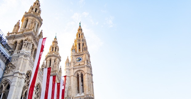 beflaggtes Wiener Rathaus vor blauem Himmel