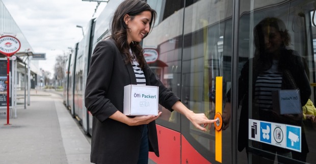 Frau steigt mit Paket in eine Wiener Straßenbahn ein