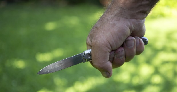 Mann hält ein Messer in der Hand